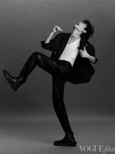 a man in black and white poses with his legs spread out while wearing leather pants