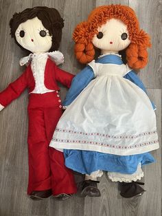 two dolls are laying on the floor next to each other