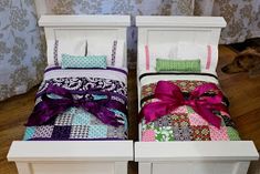 two twin beds with colorful blankets and bows on them, one is made out of white wood