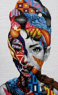 a large mural on the side of a building with a woman's face and many different colors