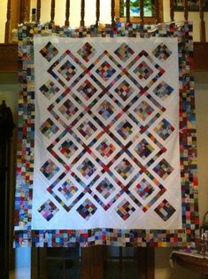 a white quilt hanging from a wooden banister