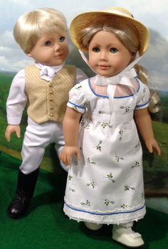 two dolls standing next to each other in front of a wall with grass and clouds