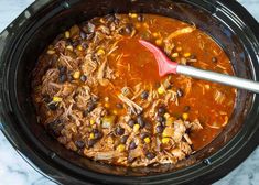 a slow cooker filled with chicken, black beans and corn