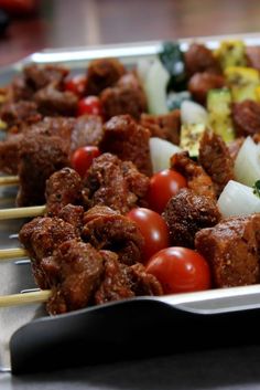 meat and vegetables on skewers in a tray