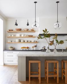 a kitchen with two wooden stools next to an island