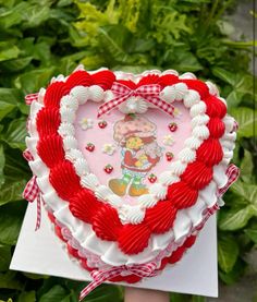 a heart shaped cake sitting on top of a white plate in front of green plants