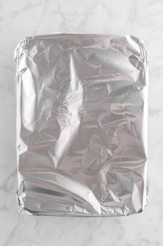 an aluminum foil covered square object on a marble surface