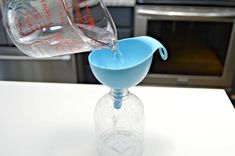 a pitcher pouring water into a glass on top of a counter