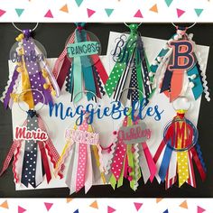 some colorful ribbons are hanging on a sign that says maggie's belles