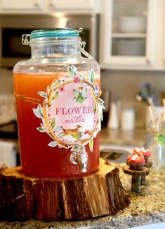 a glass jar filled with liquid sitting on top of a wooden stump in a kitchen