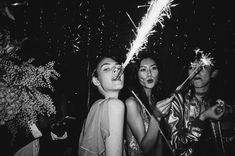 black and white photograph of people at a party with sparklers in the air above their heads