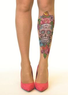 a woman's legs with colorful tattoos and pink high heeled shoes on them