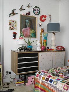 a bedroom with a bed, dresser and pictures on the wall