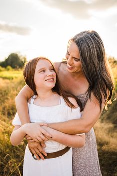 two women hugging each other in a field