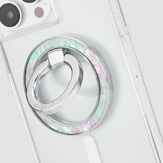 an iphone case with two rings attached to the back of it, sitting on top of a white surface