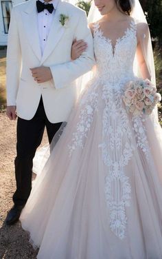 a man in a tuxedo walking next to a woman in a wedding dress