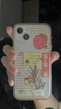 a person holding up a phone case with stickers on it's sides and writing on the back