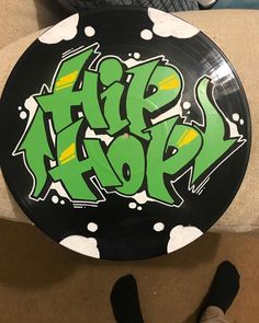 a black frisbee with green graffiti on it sitting on top of a couch