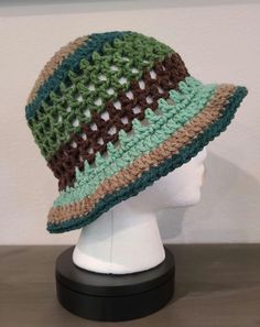 a white mannequin head wearing a multicolored crocheted hat