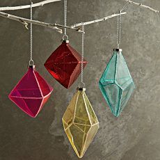 three glass ornaments hanging from a tree branch