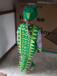 a little boy dressed up as a green dragon