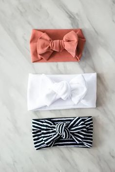 three headbands with bows on them sitting on top of a marble countertop