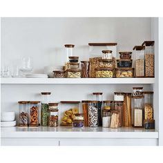 the shelves are filled with different types of food and glass containers on top of them