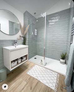 a bathroom with a shower, sink and mirror