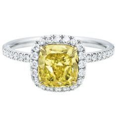 a yellow diamond ring with diamonds around it