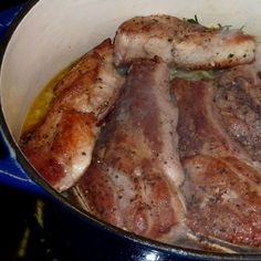 some meat is cooking in a pot on the stove