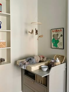 a baby crib in the corner of a room with bookshelves and toys