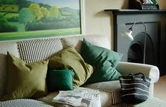 a living room filled with furniture and a painting on the wall above it's fireplace