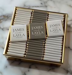 three business cards in a gold box on a marble counter top, with the name james laya printed on them