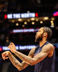 a basketball player with tattoos on his arms