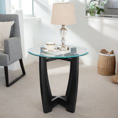 a glass table with a lamp next to it