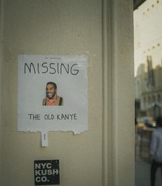 a missing sign posted on the side of a building next to a man's face