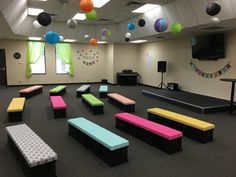 an empty room with benches and balloons hanging from the ceiling