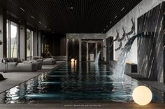 a large indoor swimming pool with waterfall in the middle