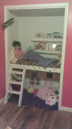 two children laying on top of bunk beds in a room with pink walls and wooden floors