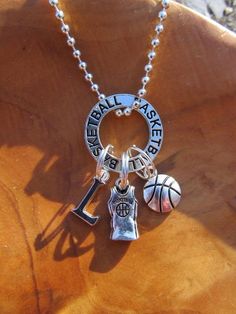 a basketball necklace with charms attached to it