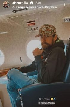 a man sitting in an airplane seat with his hand on his chin