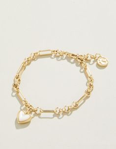 Capture that warm feeling of a full heart in this charming Full Heart Bracelet. A thick piece of shimmering mother-of-pearl is set in a lustrous 18kt matte gold plated setting on a detailed chain. Timeless and lovely. Gold Bracelet Stack With Watch, Pretty Jewellery Gold, Wishlist Items Aesthetic, Cute Gold Jewelry, Cute Charm Bracelets, Good Bracelet, Gold Beaded Bracelets, Fantasy Earrings, Dainty Gold Bracelet