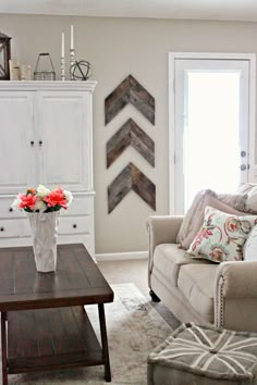 a living room filled with furniture and flowers in a vase on top of a coffee table