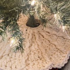 a white knitted blanket under a christmas tree