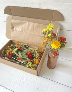 an open cardboard box with flowers in it