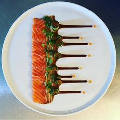 a plate topped with slices of salmon covered in sauce