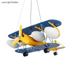 a yellow and blue toy airplane suspended from a string with two white balls attached to it