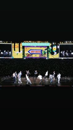 a group of people that are standing on a stage with some lights in the background