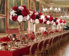 the centerpieces are adorned with red flowers and candles for an elegant wedding reception