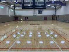 an indoor basketball court with hard wood flooring